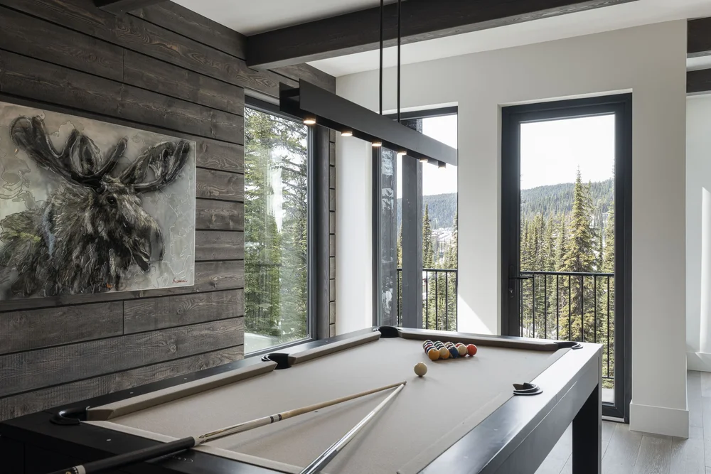 Games room with the pool table and windows onto the trees and hills