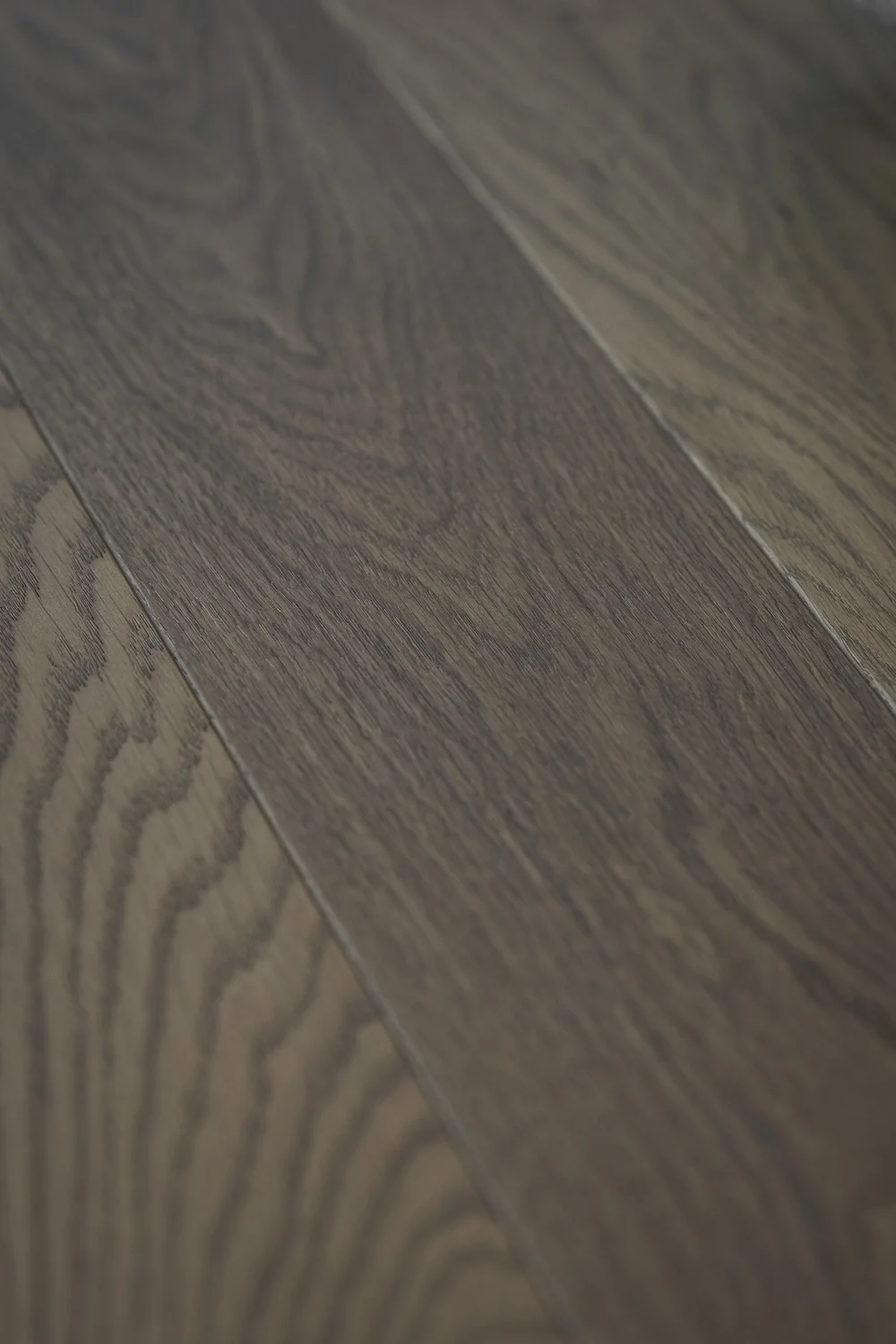 Wide floor boards running diagonally, the grain lit across the joints