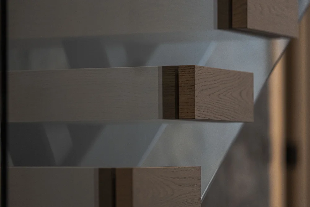 A glass balustrade panel set into the end of a timber tread, seen close