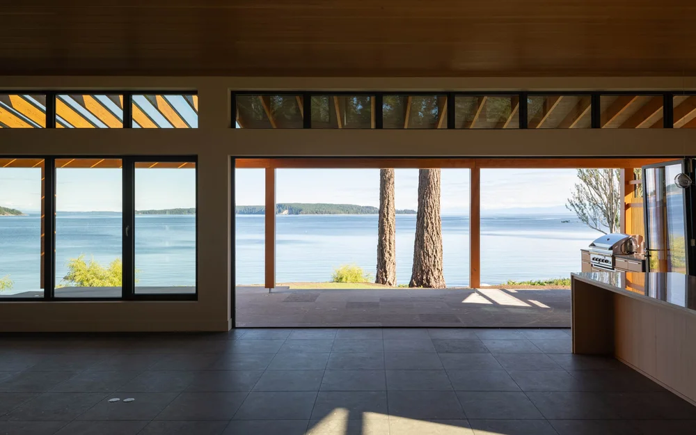 Living space opened to the terrace, two trunks and the water framed in the opening