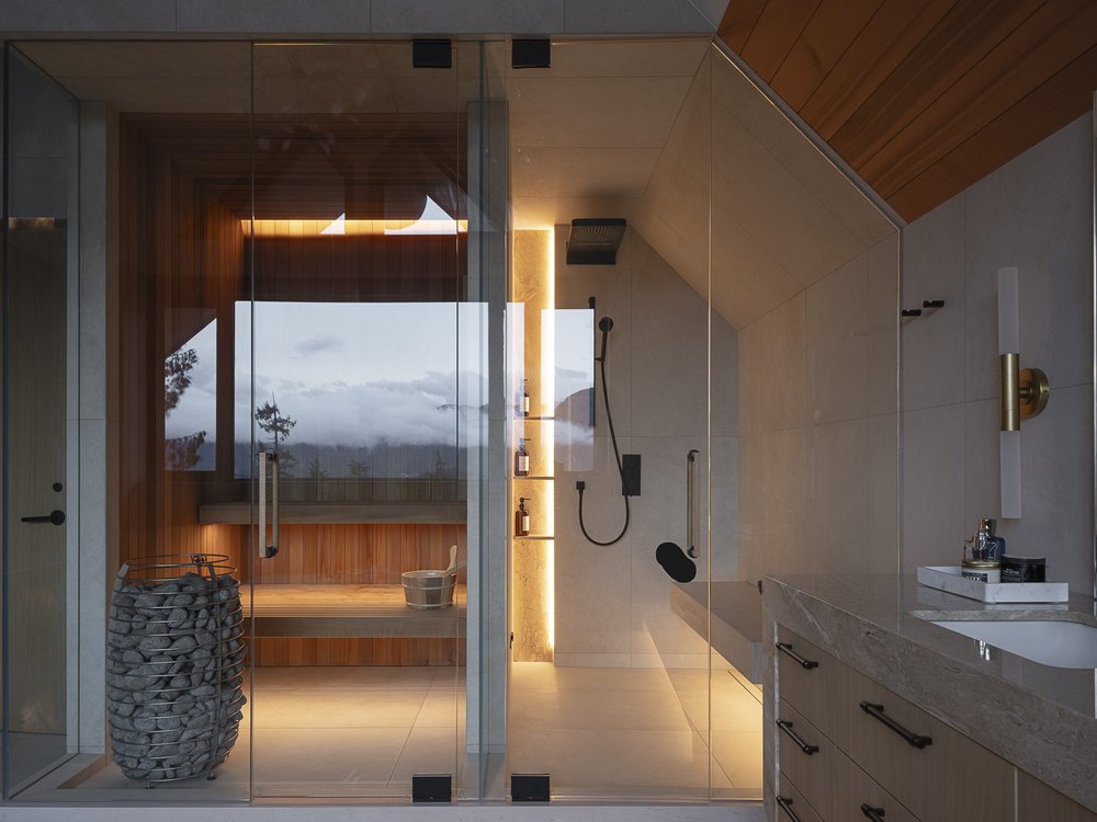 Through glass into the sauna and shower, a window onto trees and low cloud