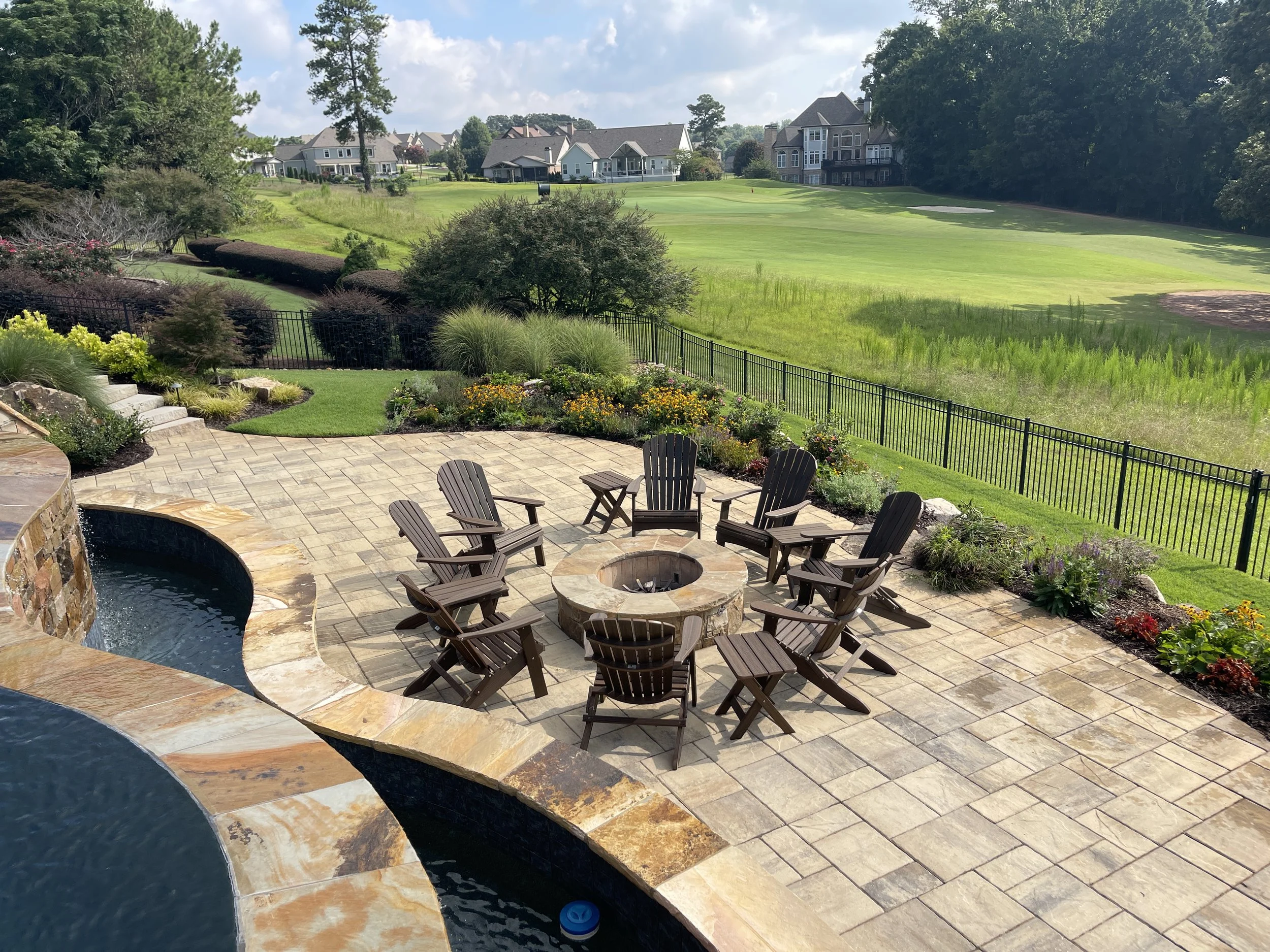 Stone paver patio with built-in fire feature and open backyard views in Braselton, GA