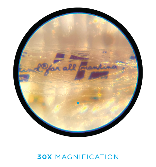 Close-up view of a small object with handwritten text that reads 'for all martina' on a reflective surface