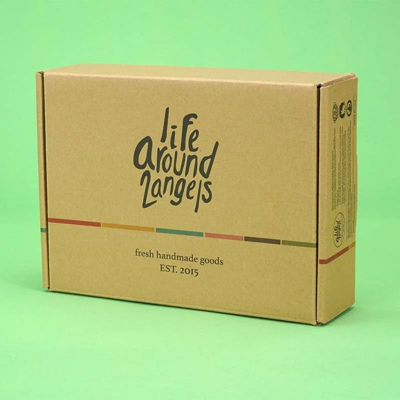 A cardboard box with the label "life around angels" and the text "fresh handmade goods," established in 2015, placed against a light green background.