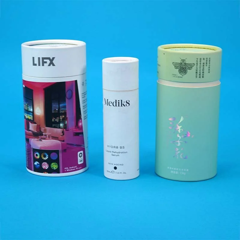 Three cosmetic or skincare product containers on a blue background, with different sizes and designs.