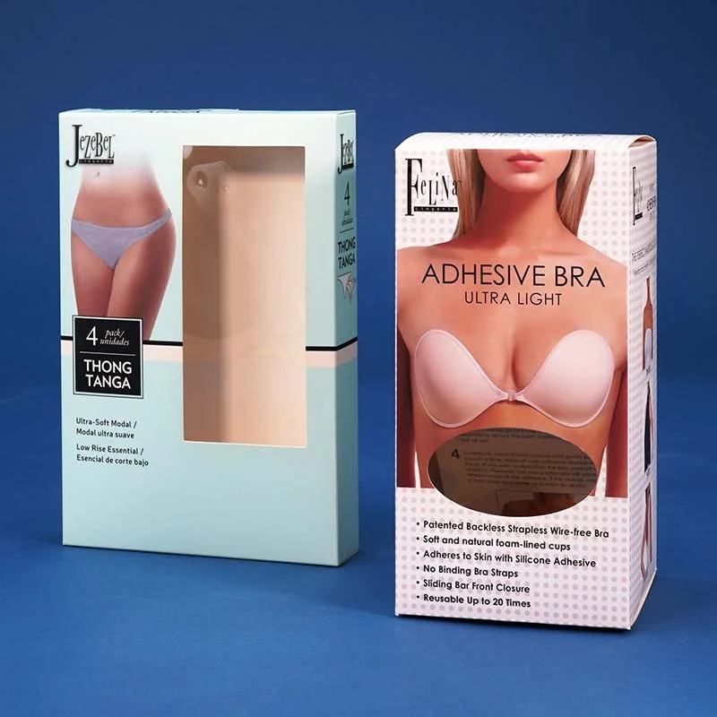 Boxes of adhesive bras and strapless tongs tanga underwear, with images of women wearing the products on the packaging, set against a blue background.