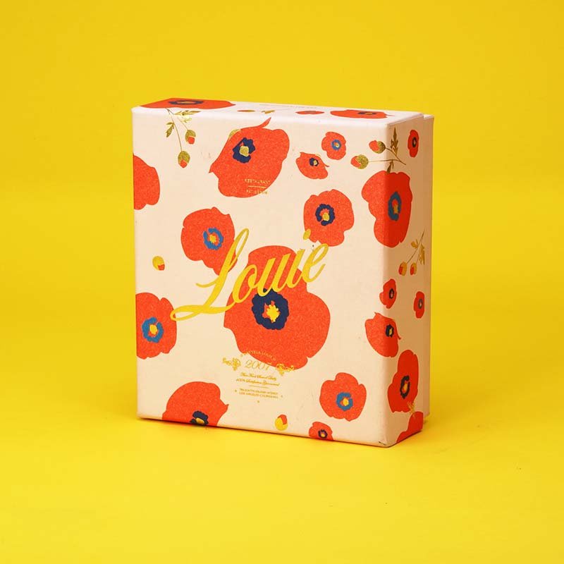 A Louise perfume box with a colorful floral pattern on a yellow background.
