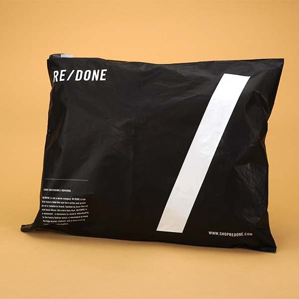 Black resealable bag with white geometric design and the word "RE/ DONE" on the top left. Background is beige.
