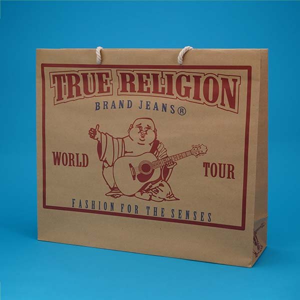 A brown paper shopping bag with red and blue text and a graphic of a Buddha playing a guitar, against a blue background.