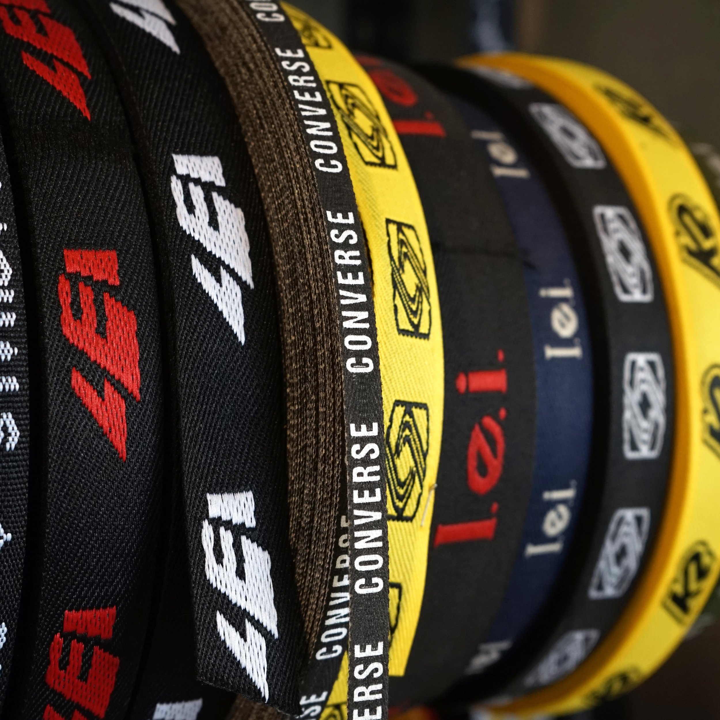 Rows of sports wristbands with various colors and logos, featuring the Converse brand logo and the words 'Converse' and 'Tell'.