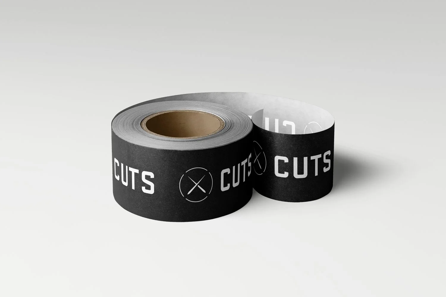 Two rolls of black tape with white text and symbols, one rolled out slightly to show the inside, placed on a white surface.