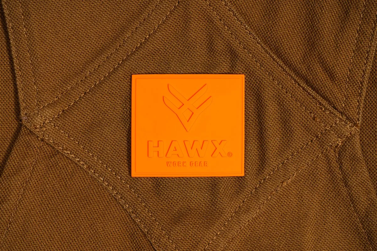 A close-up of a brown quilted fabric with an orange square patch that has the brand name "HAWX" and the words "WORK GEAR" on it.