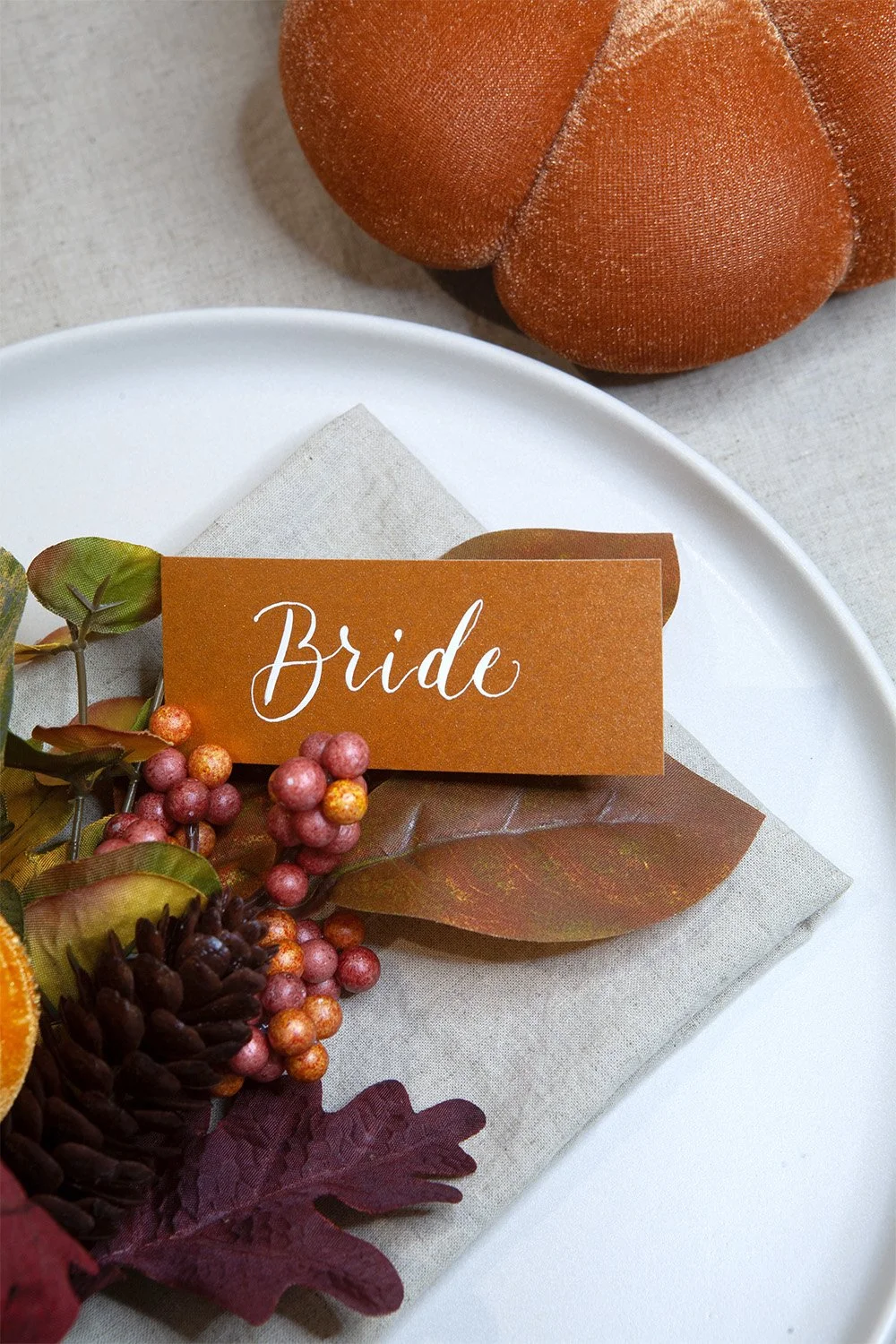 White-calligraphy-place-cards-on-metallicorange.jpg