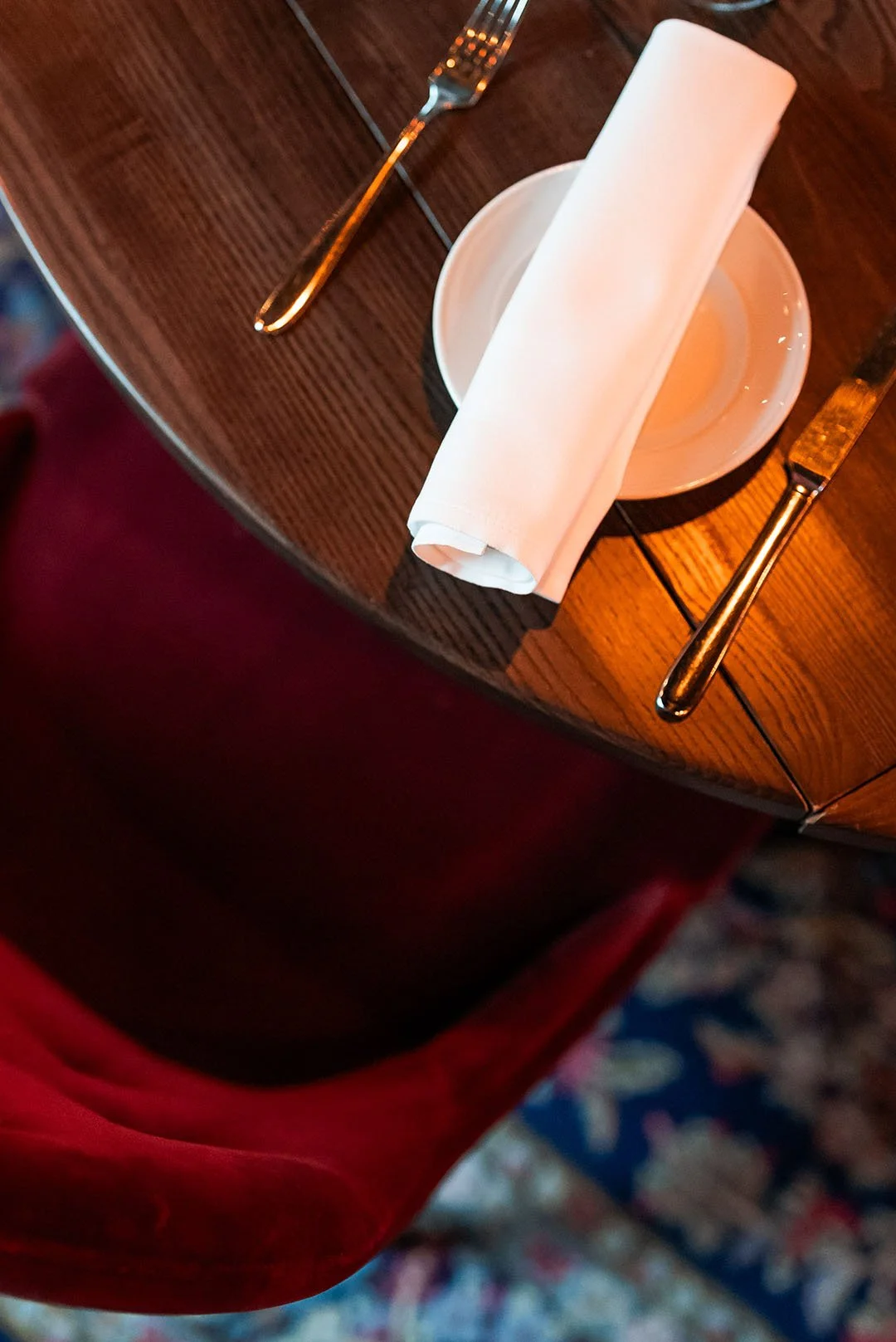 Ett bord med en vit servett, en tom liten skål och bestick, troligen för en måltid.