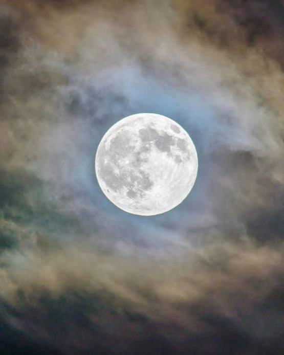 Full moon in a cloudy night sky.