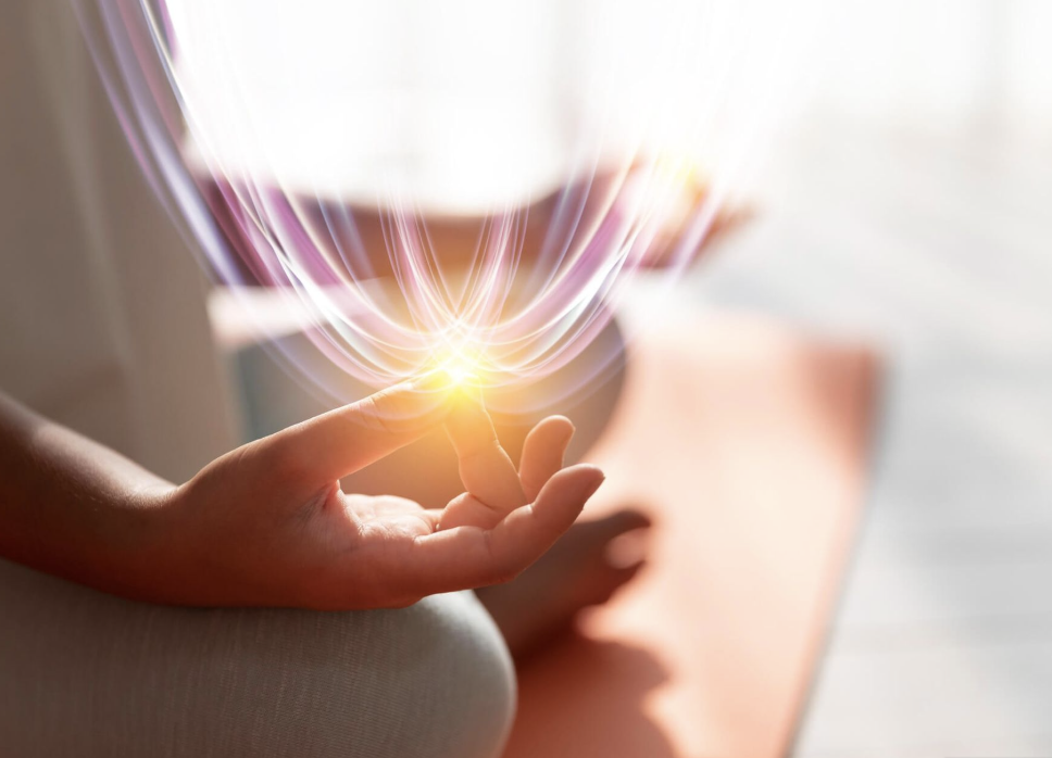 Person's hand with finger touching a glowing, magical energy orb with radiating light and waves of energy