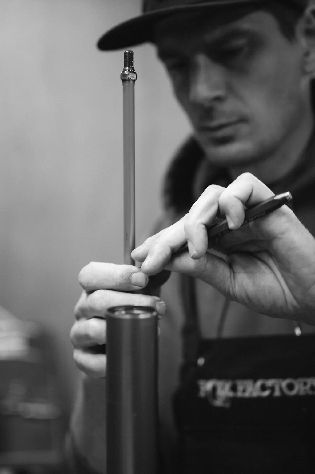 A person is carefully performing an experiment or task with a pipette and a small test tube, in a laboratory setting.