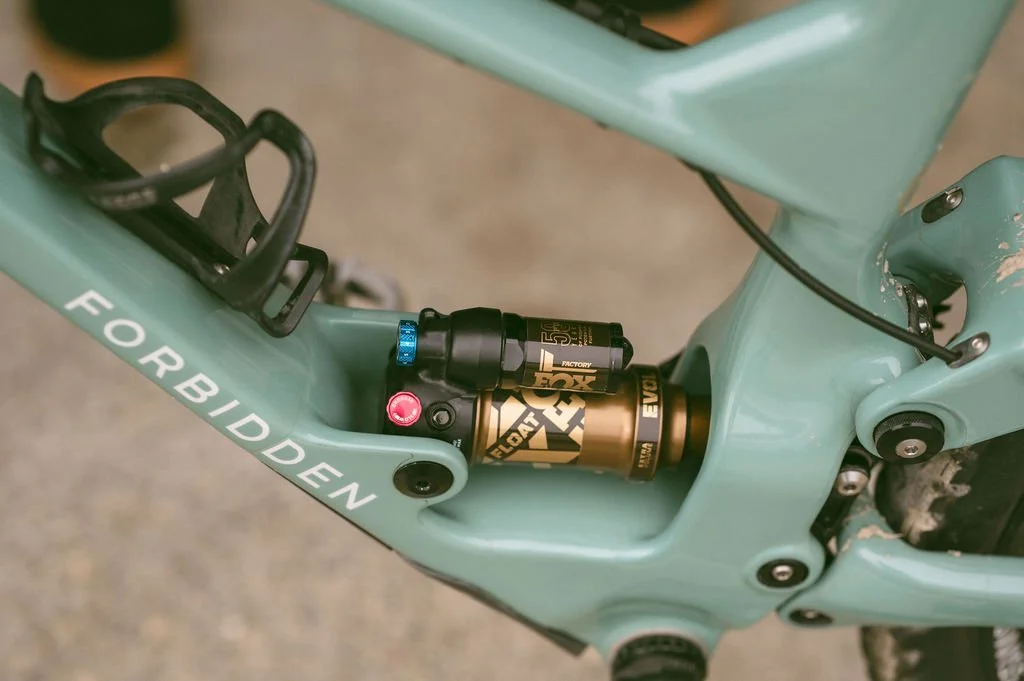 Close-up of a light green mountain bike frame with a Fox Factory suspension shock.