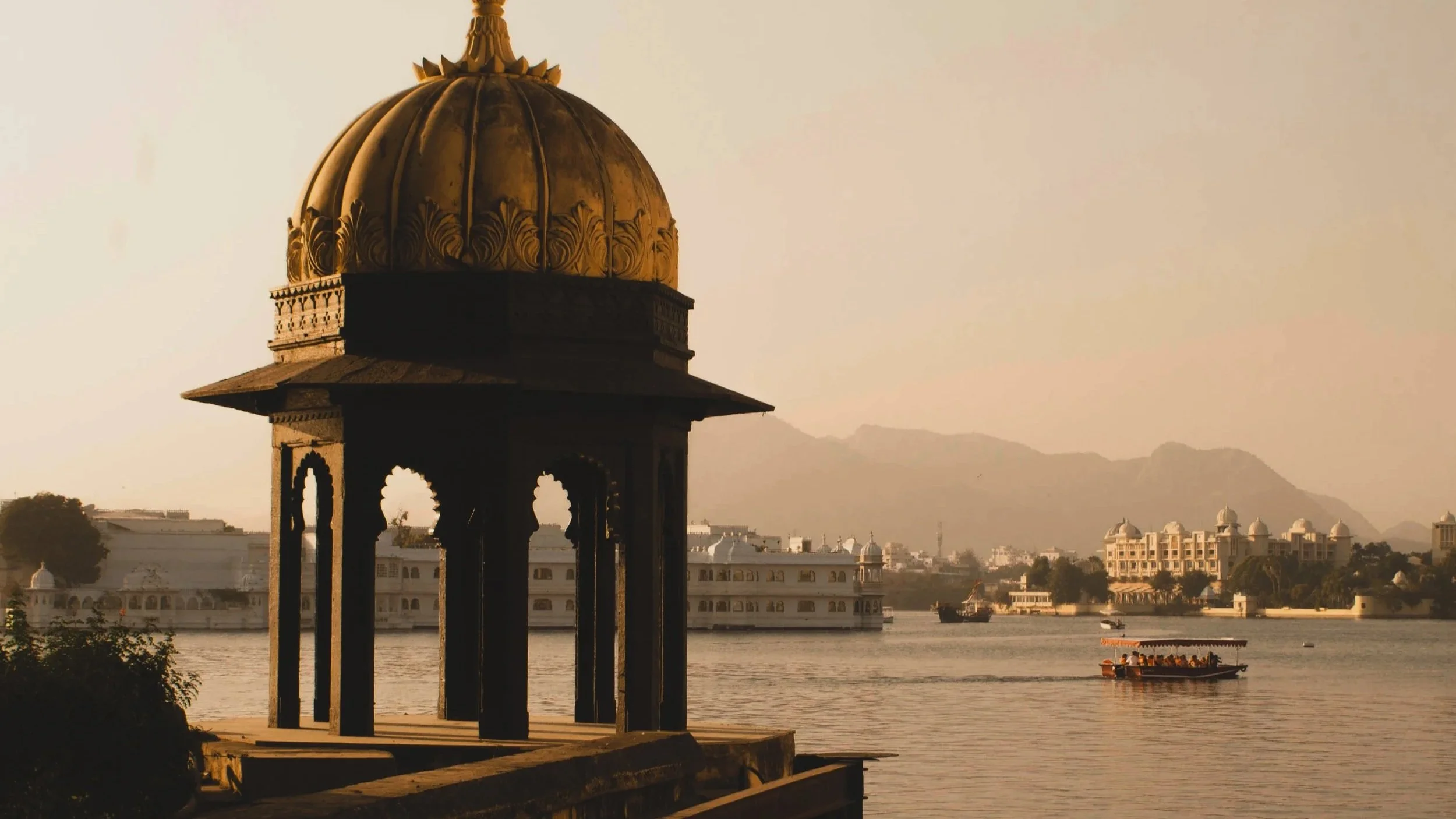 A mosque overlooking a body of water with a boat on it