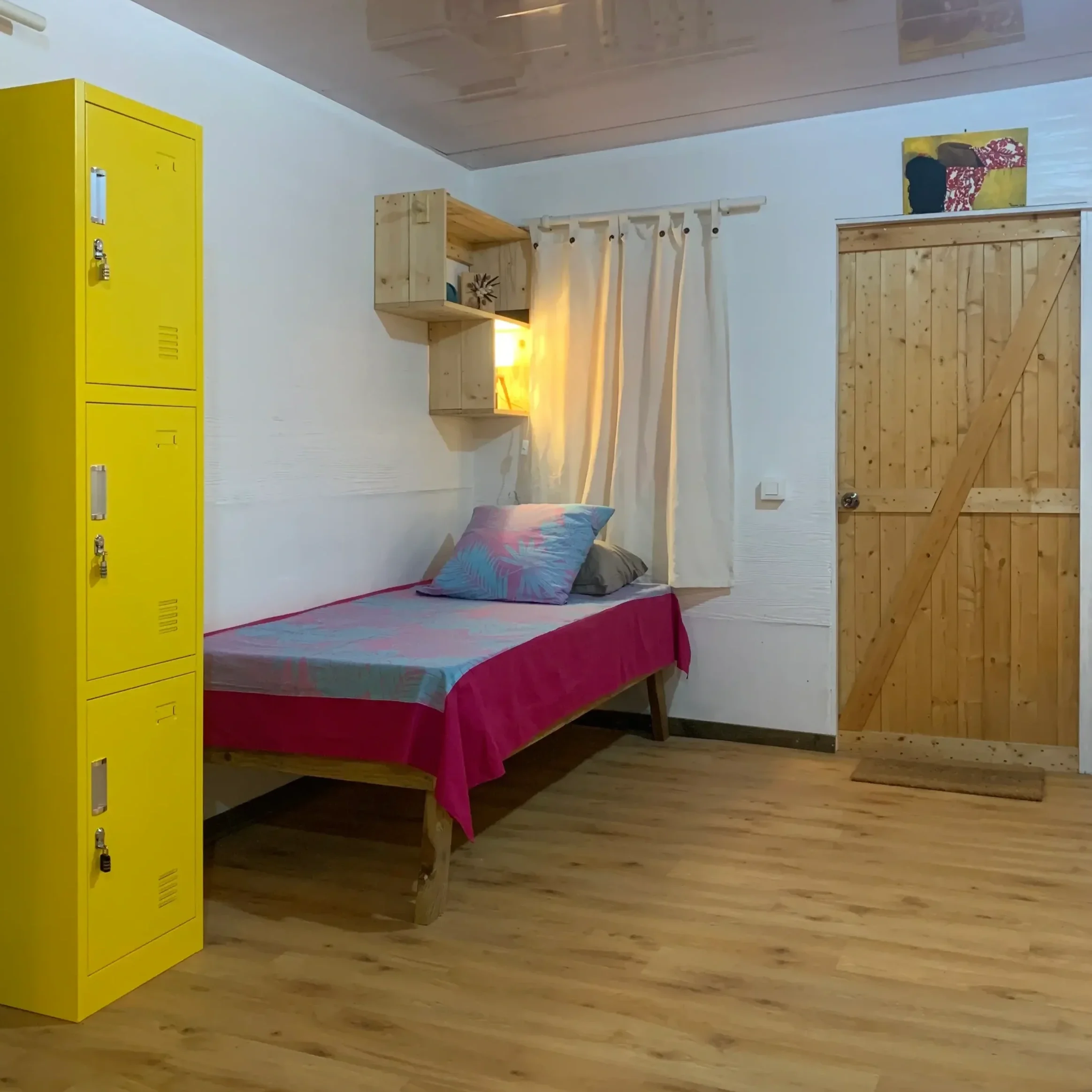 single bed in a cozy and colored dorm on the island of Rangiroa