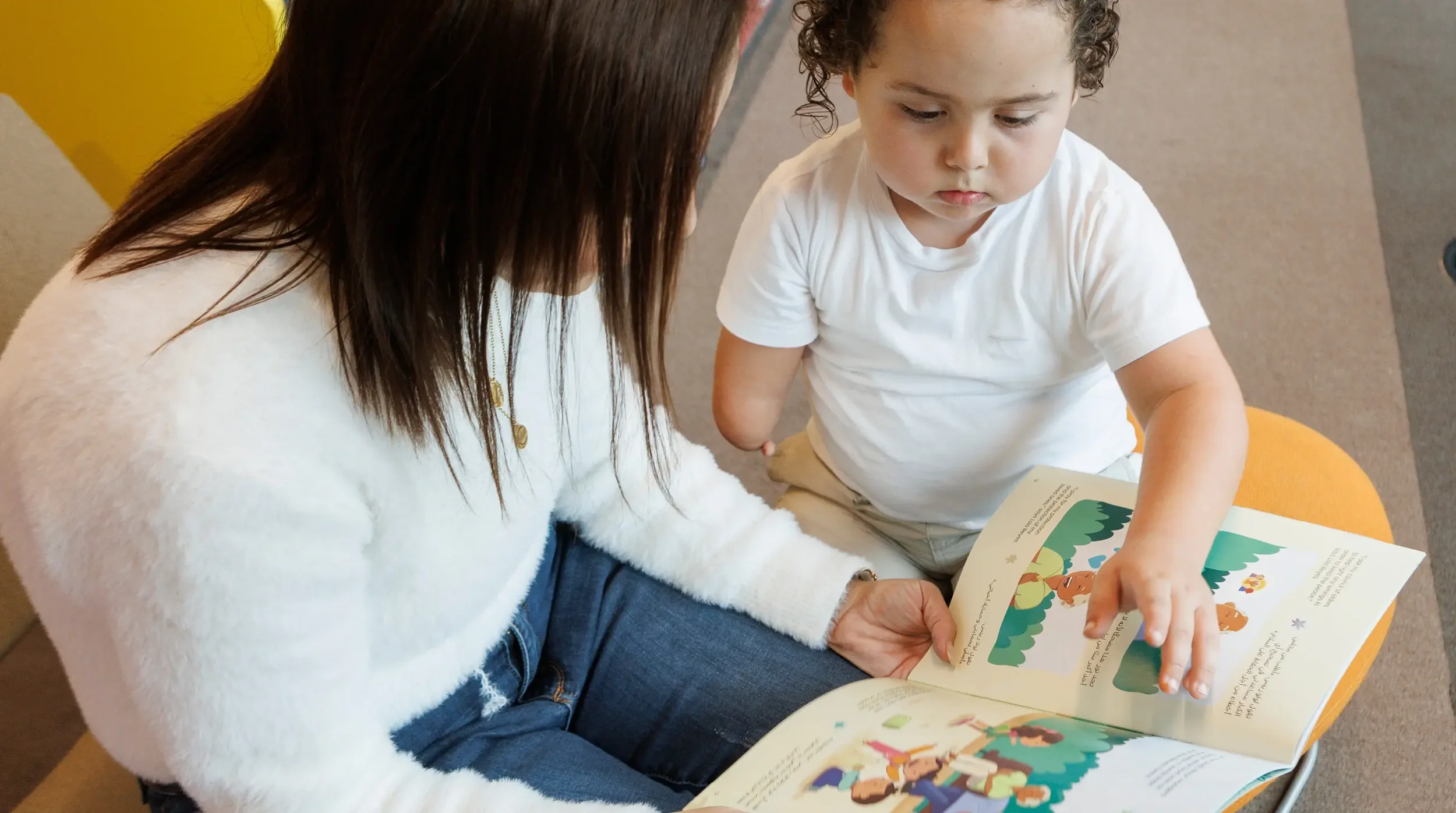 A mother reading a multilingual book to her child