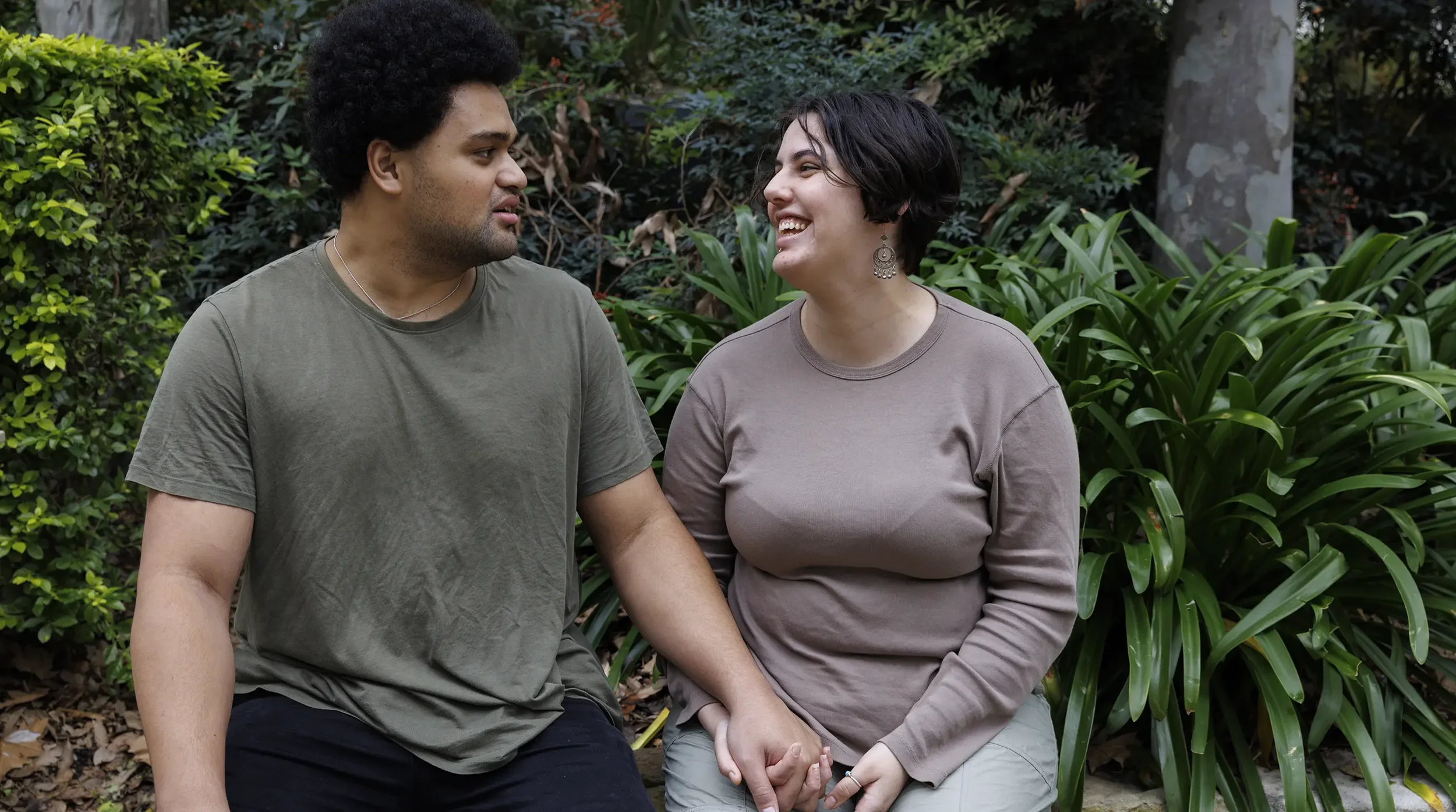 Multicultural couple living with disabilities sitting in a garden