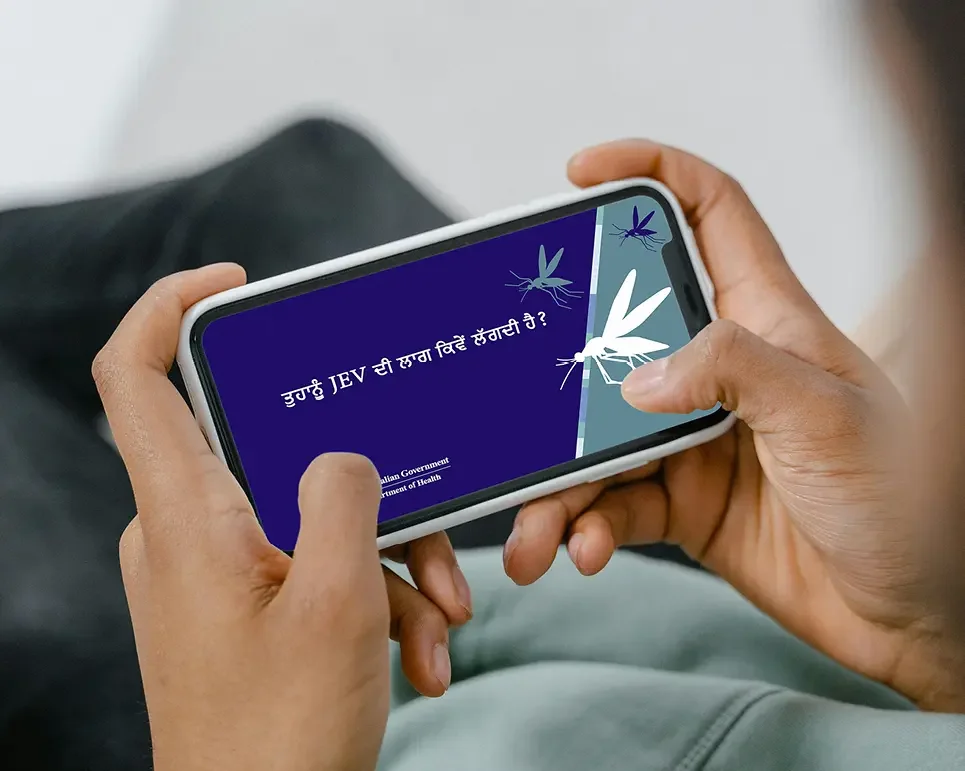 Man watching JEV campaign translated video on his mobile phone