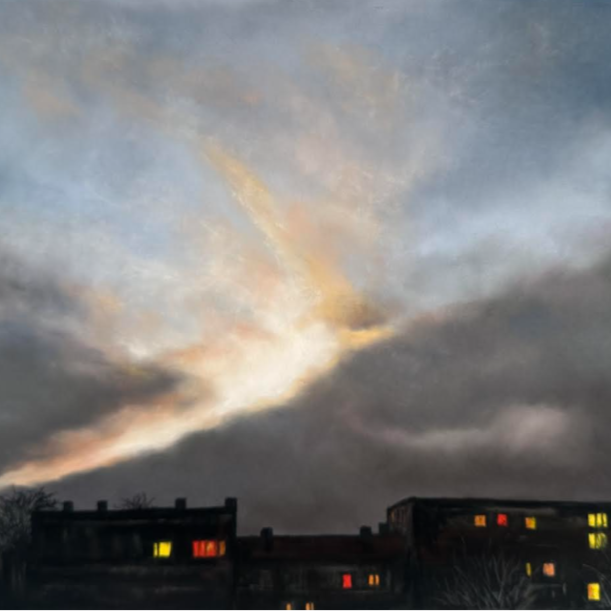 Overcast sky at dusk with colorful cloud formation, silhouetted buildings with illuminated windows in foreground.