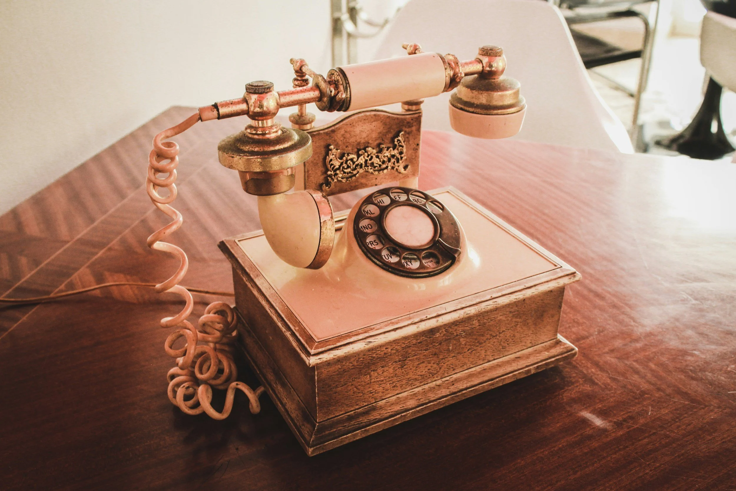 Vintage rotary telephone on a wooden table.
