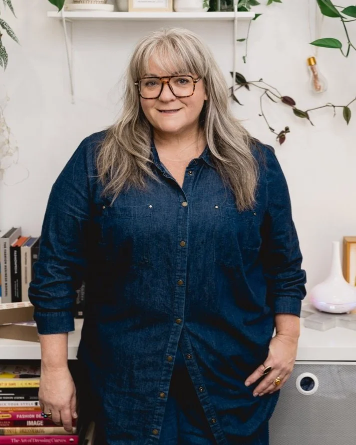 Kerry Pietrobon, fashion consultant, smiling in a denim shirt in her creative workspace.