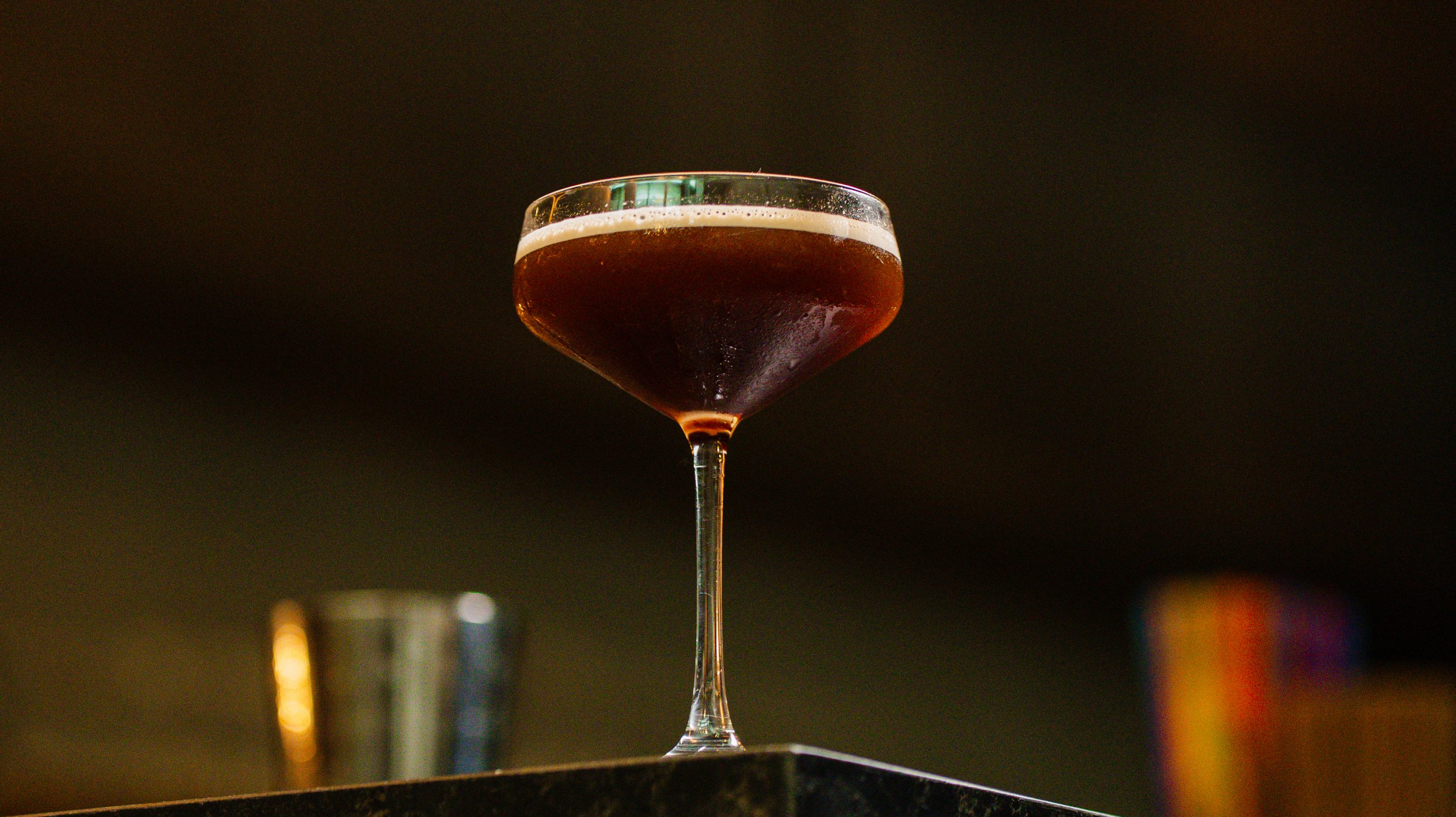 Close-up of a signature dark craft cocktail representing the new late-night dining and drinks menu at Zōtō, an elevated izakaya in Sarasota.