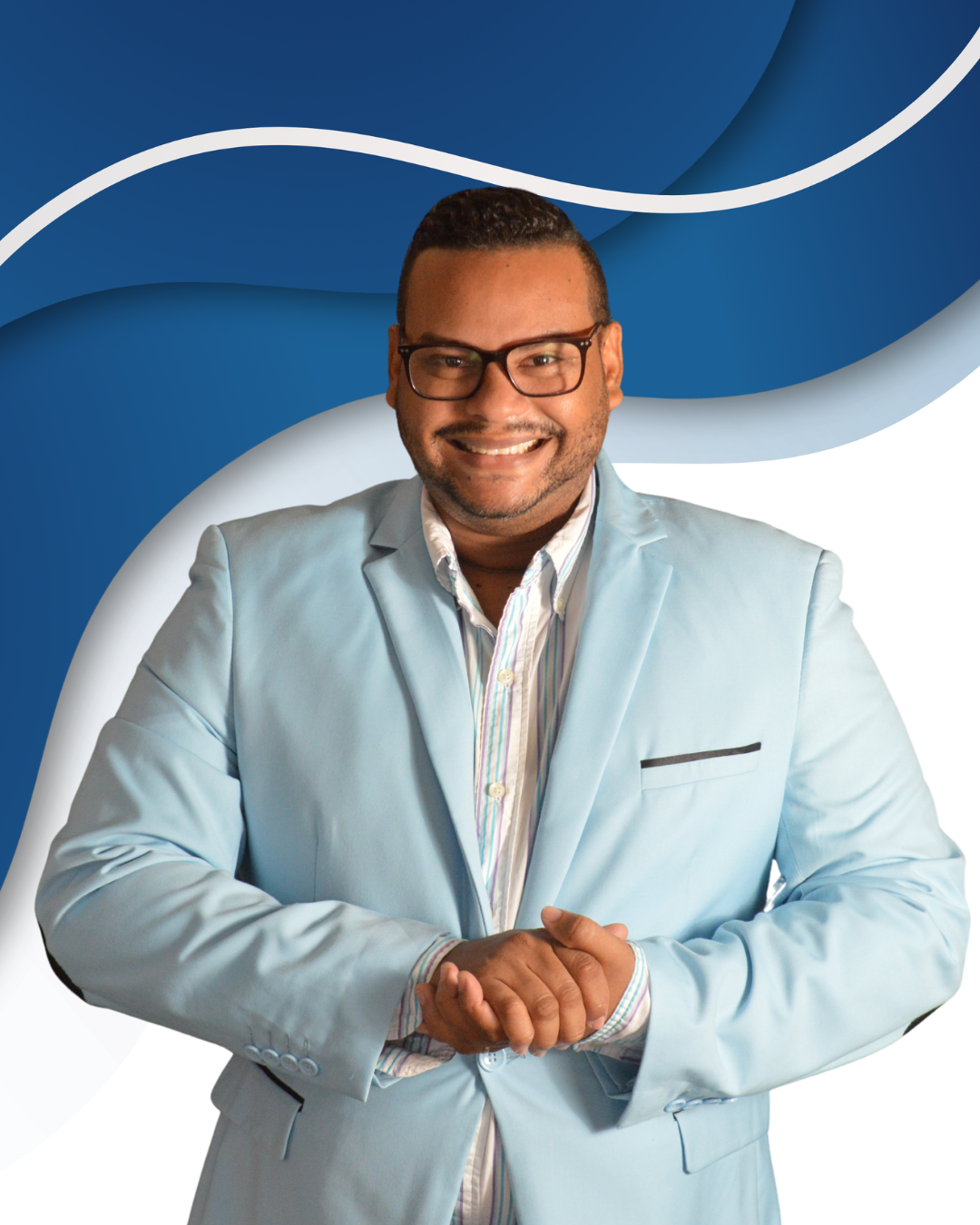 Hombre sonriendo, con barba y gafas, vestido con saco azul claro y camisa a rayas, en fondo azul y blanco con diseño abstracto.