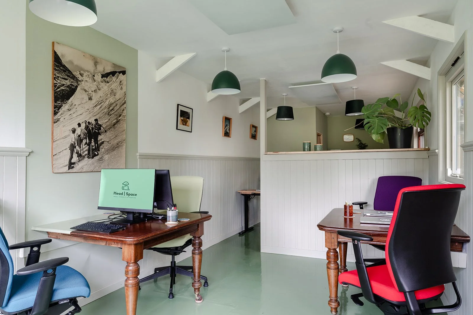 multiple desks and office chairs and display screens inside a remote co-working space in the scottish highlands