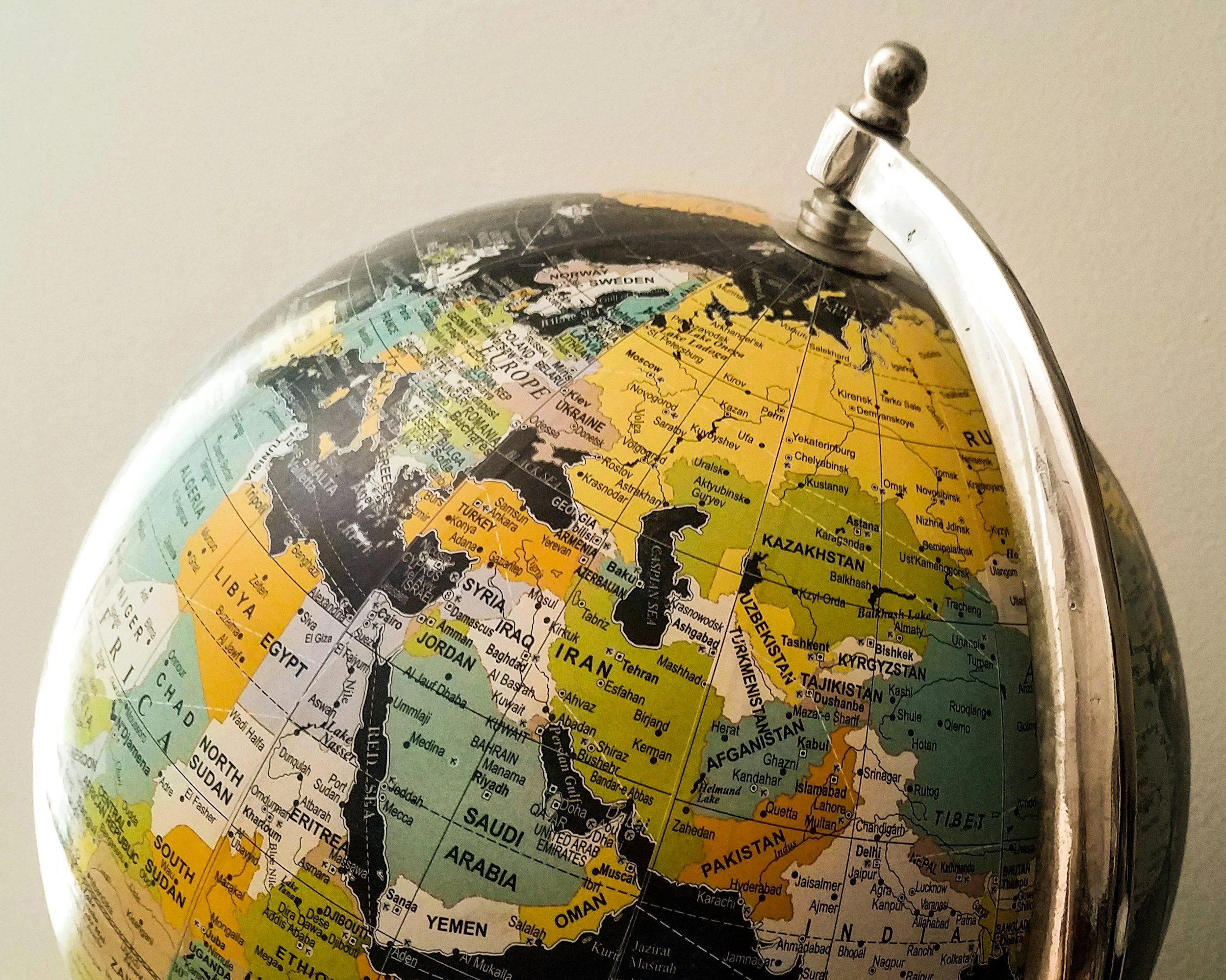 Close-up of a globe focusing on Europe, Asia, and parts of Africa showing country names and borders.