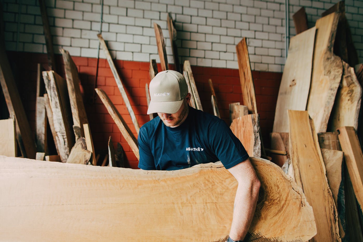 Skilled tradesman inspecting hardwood materials in workshop, quality-focused approach to custom extensions in Hills District renovation projects