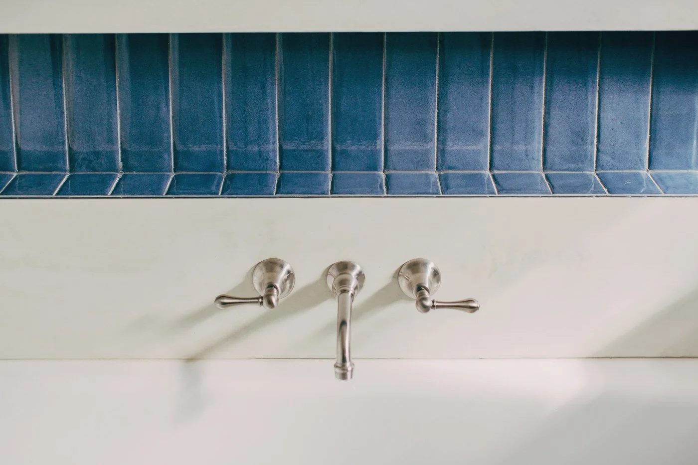Bathroom faucet detail with blue subway tile backsplash from a Cherrybrook home undergoing custom extension renovation