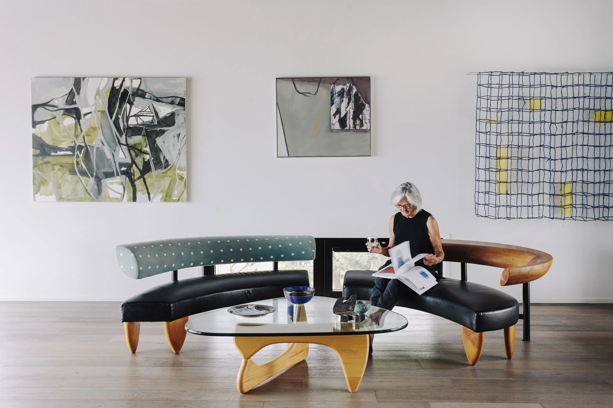 Homeowner enjoying contemporary living space with curated artwork, reflecting the lifestyle quality delivered through granny flats in North Shore and luxury renovations