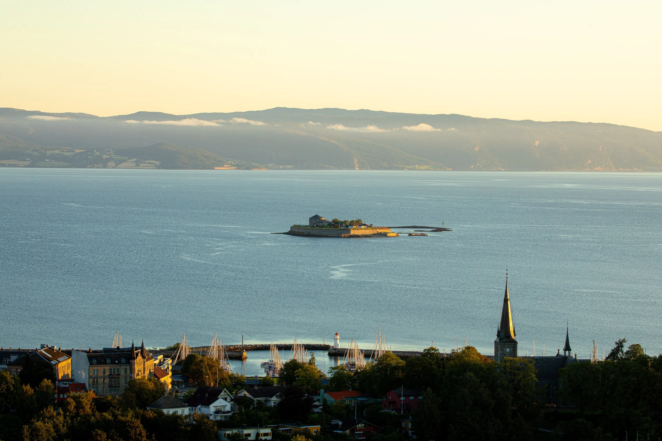 Utsikt over Trondheim by, Trondheimsfjorden, fjell og Nidarosdomen, fotografering i solnedgang eller tidlig kveld.
