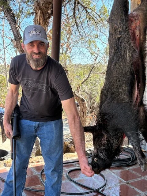 Posing with a dressed wild hog