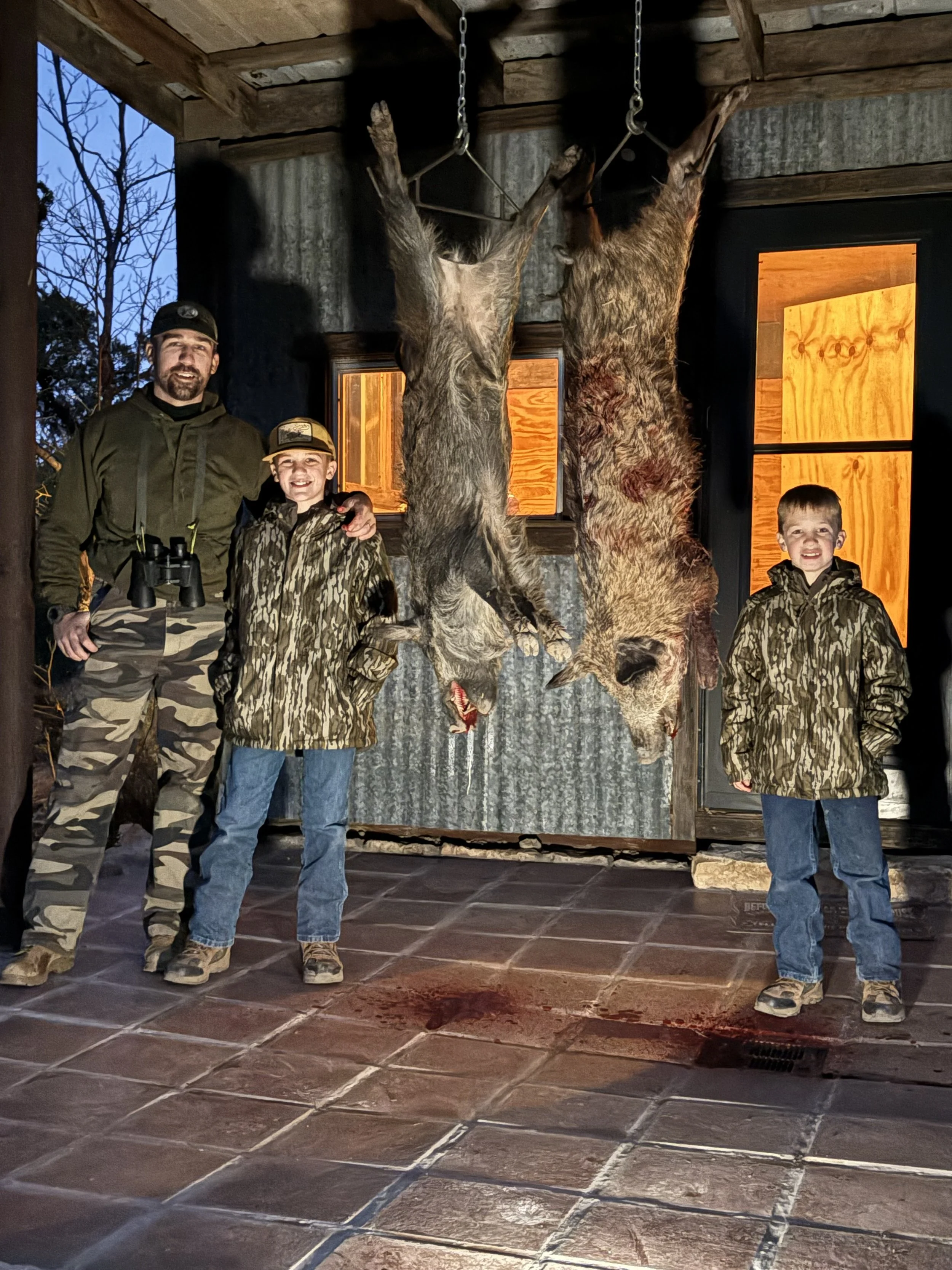 Father and sons pose with hogs that are ready for processing