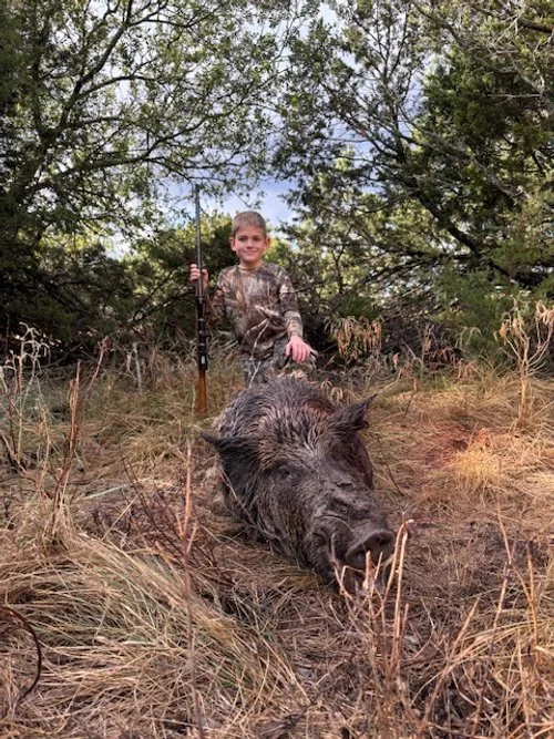 Young hunter bags his first hog.