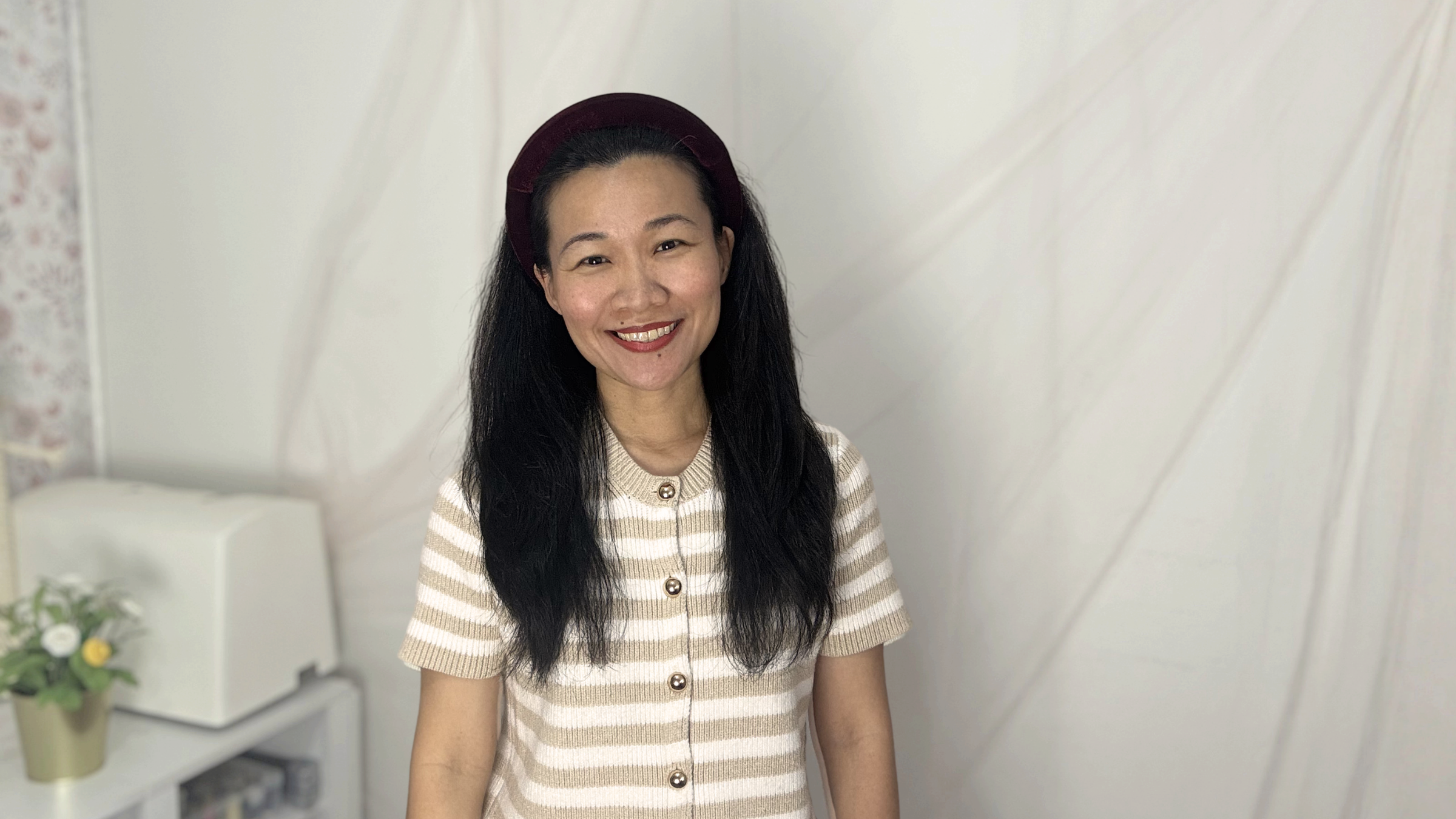 Catherine Yang wearing a burgundy headband in a soft studio setting for Catherine Yang Studio.
