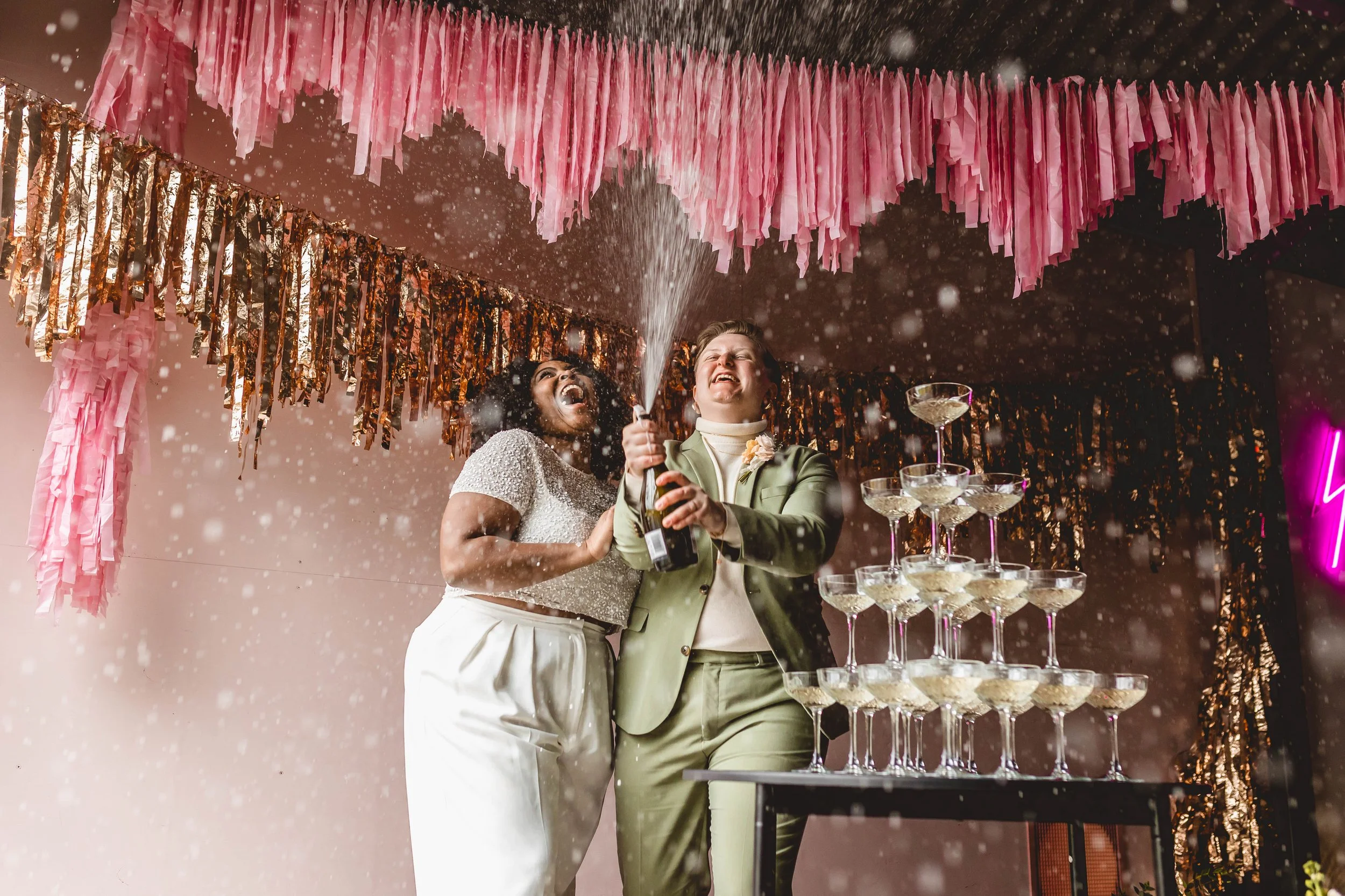 lgbtq couple celebrate with a champage spray at the giraffe shed, wales