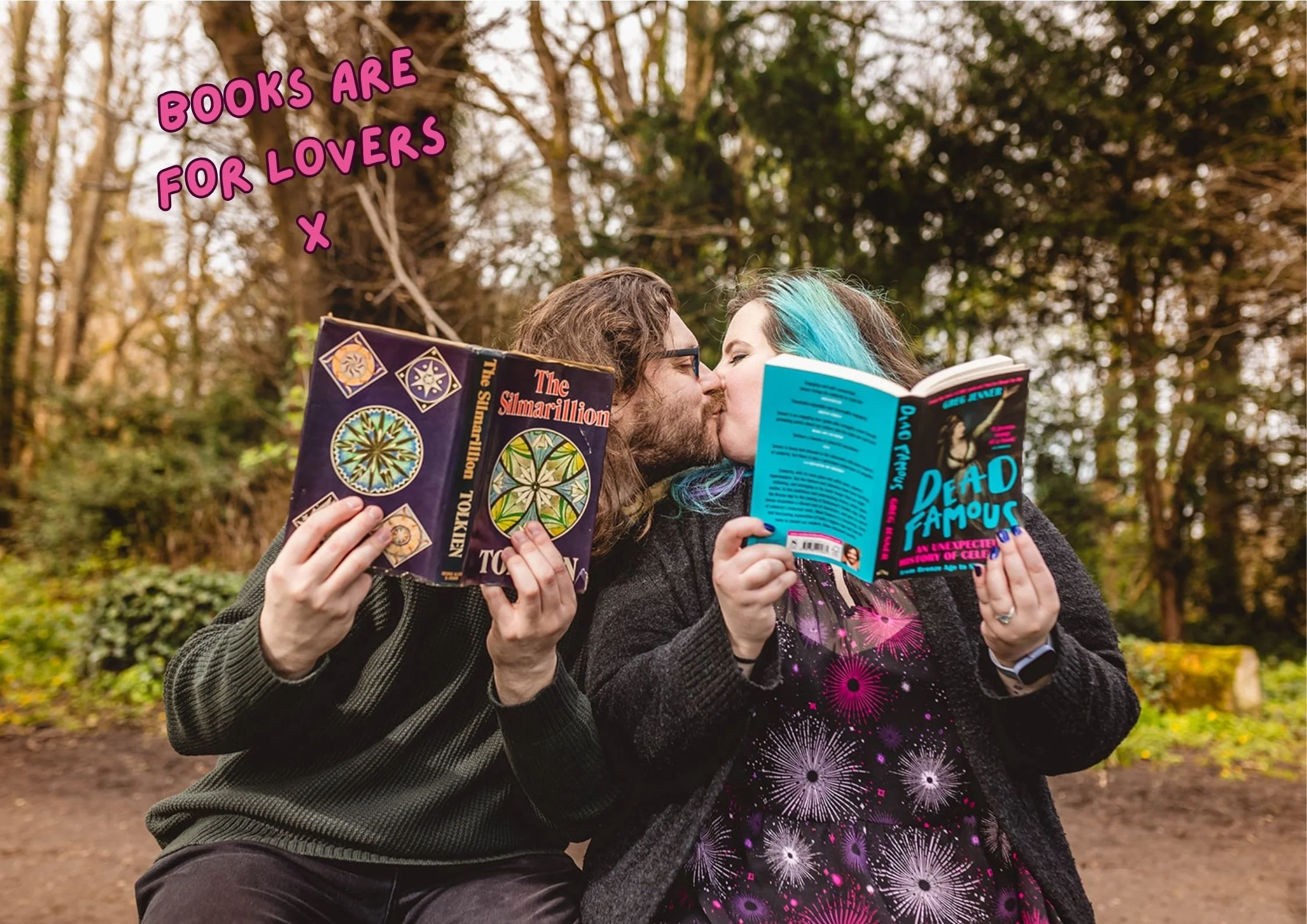 A YOUNG ALTERNATIVE STYLED COUPLE SIT ON A BENCH AND SNEAK A QUICK KISS WHILST HOLDING UP THIER FAVOURITE NOVELS TO OBSCURE THEIR FACES SLIGHTLY
