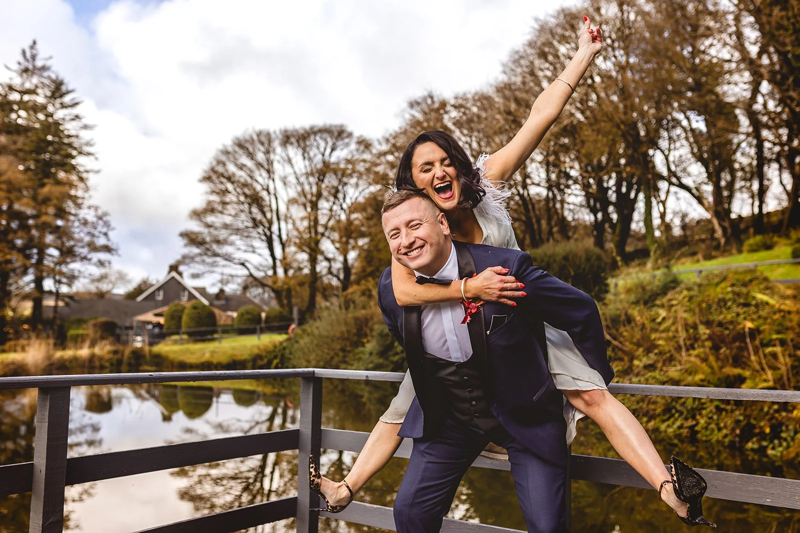 newly married couple celebrate with a fun piggyback photo outside gellifawr woodland retreat