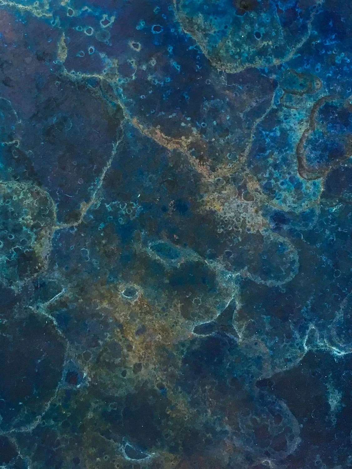 Detail of a navy, azure and turquoise marble effect patina on a metal surface