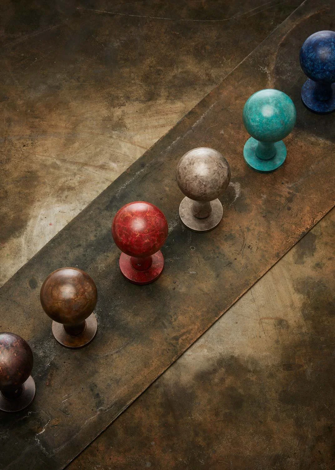 Row of Ize Ltd colourful patinated door knobs