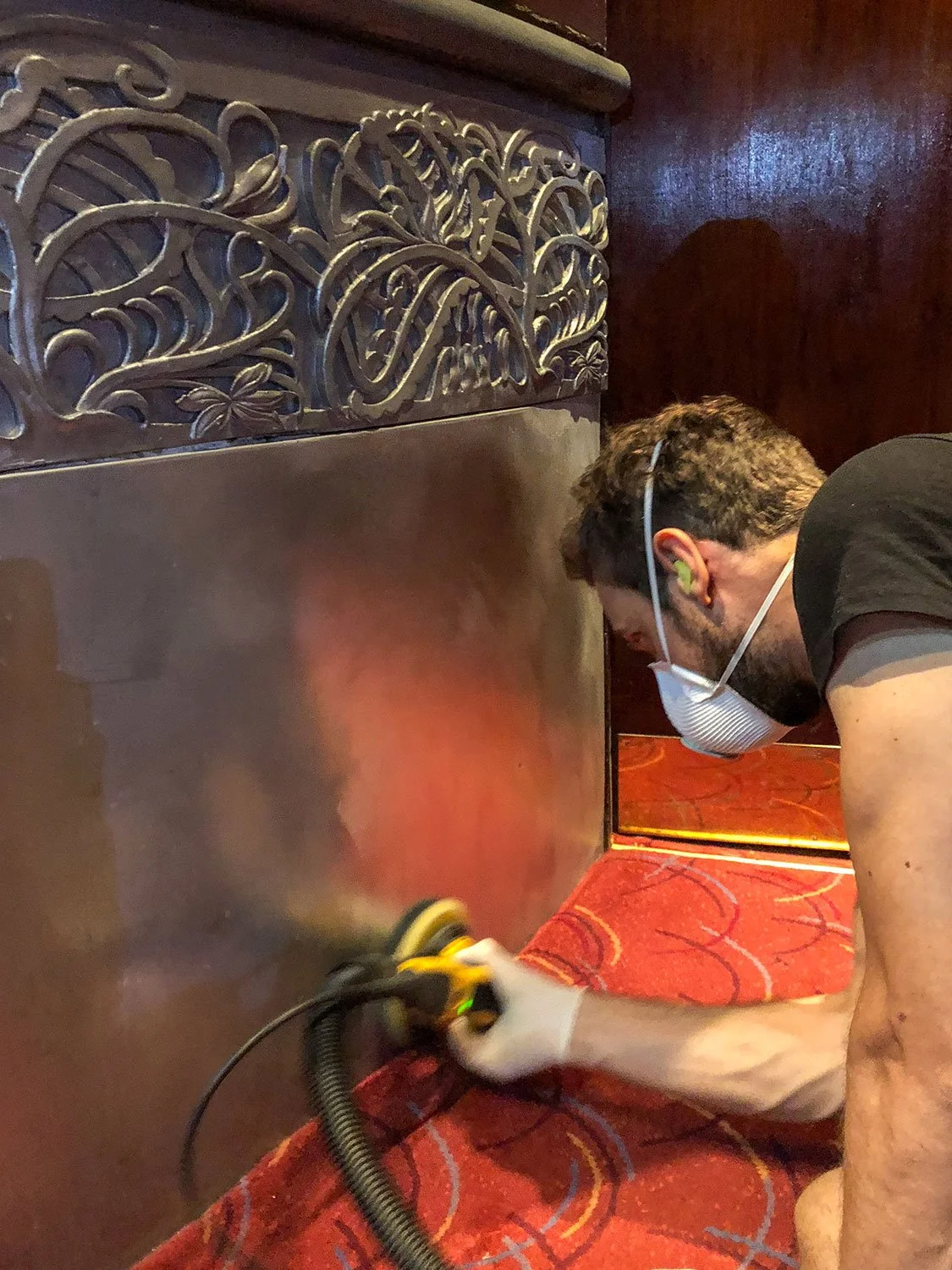 Derek Bayley restoring metal panels in the Prince of Wales Theatre auditorium 