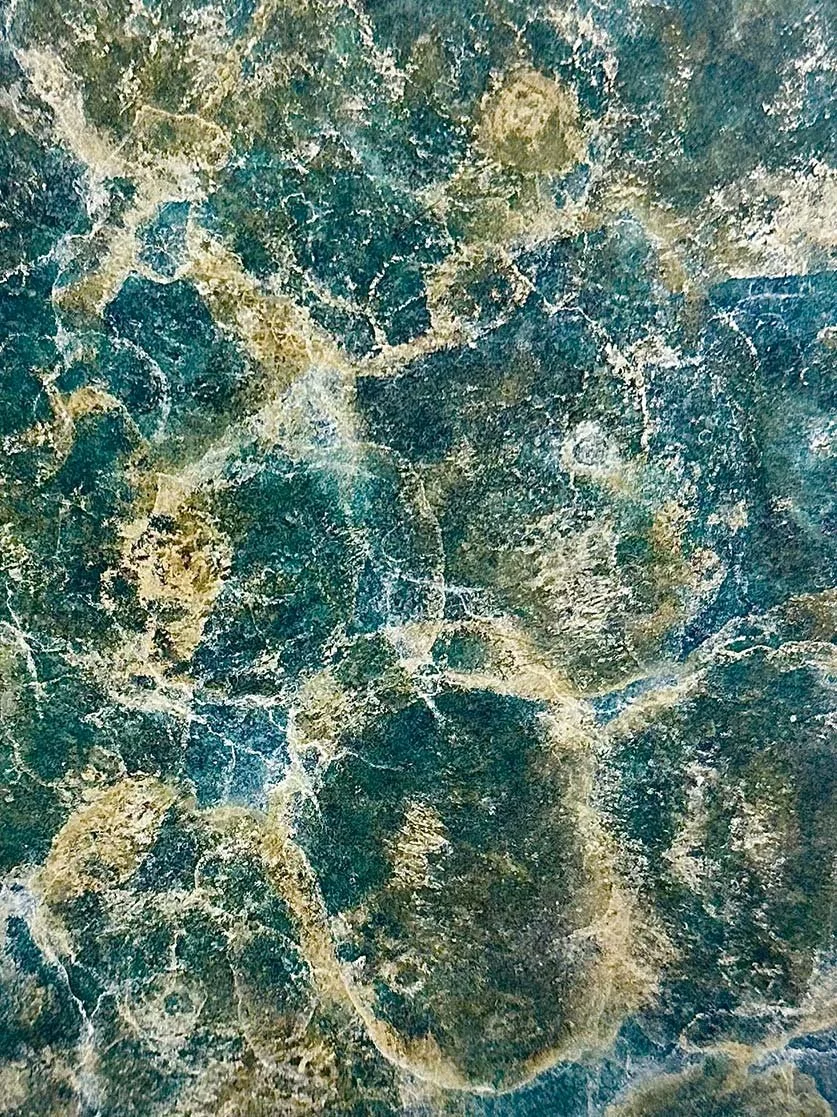 Abstract forest green, teal and yellow marble effect patina on a metal surface