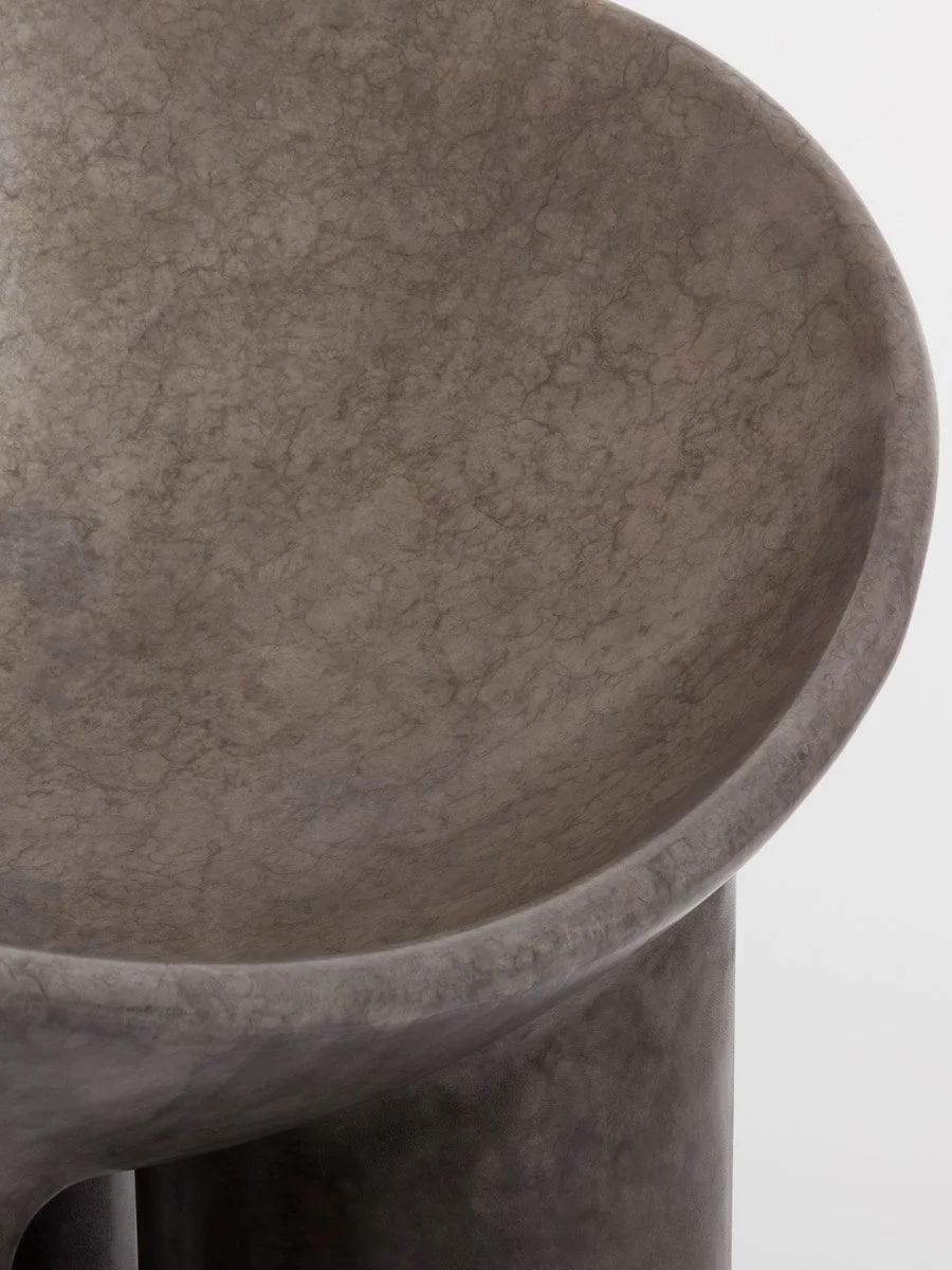 Close up of a Faye Toogood Roly Poly chair in bronze with a silver patina